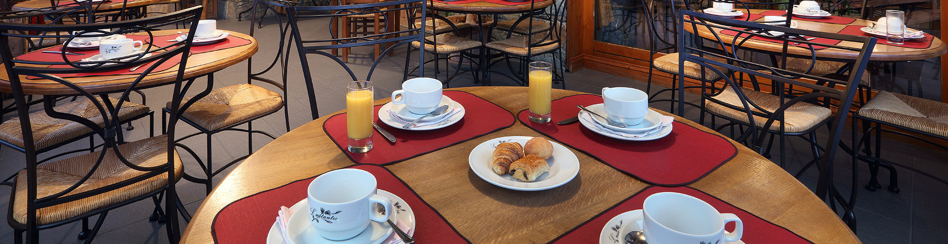 Photo de plusieurs table avec un petit déjeuner.